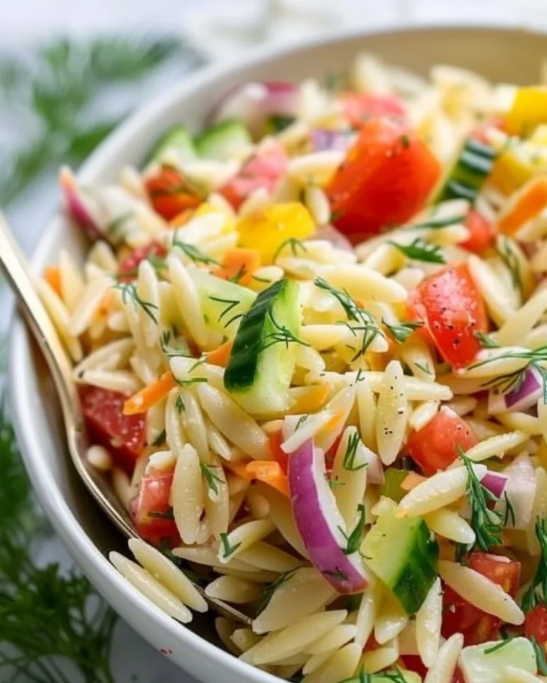 Colorful Orzo Salad with vegetables and dressing in a bowl