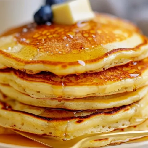 Plate of fluffy butter-free pancakes with syrup and berries