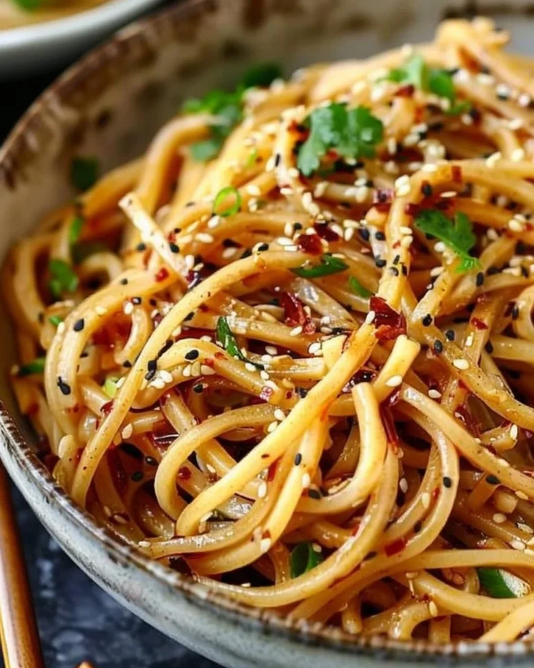 Delicious garlic sesame noodles served in a bowl with chopsticks.