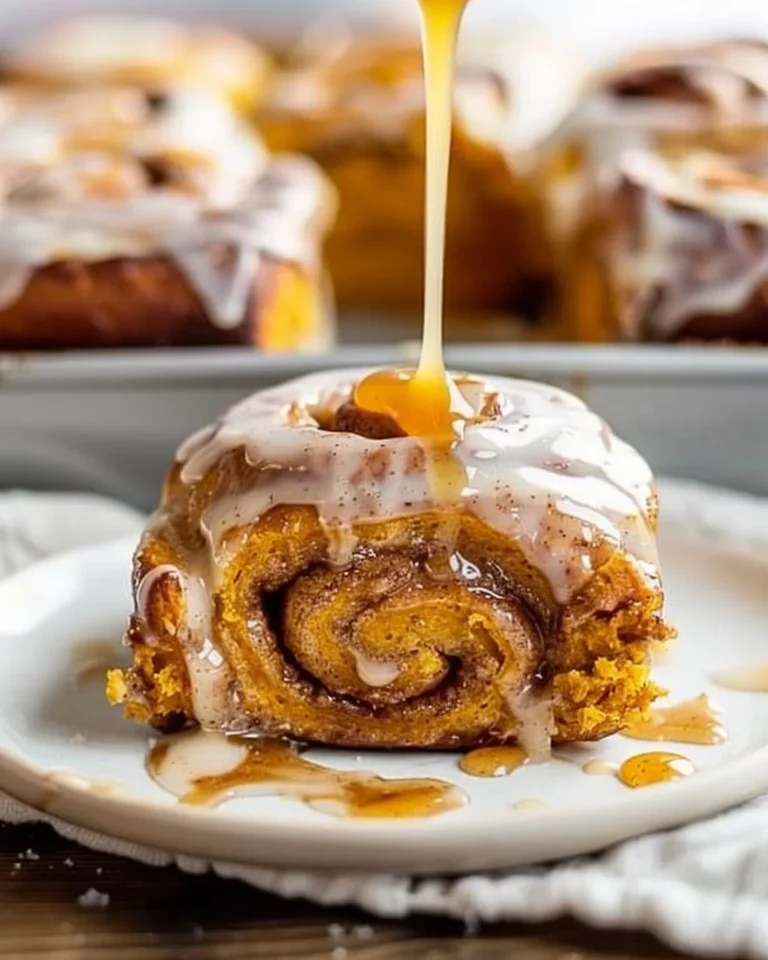 Freshly baked pumpkin cinnamon rolls with cream cheese frosting