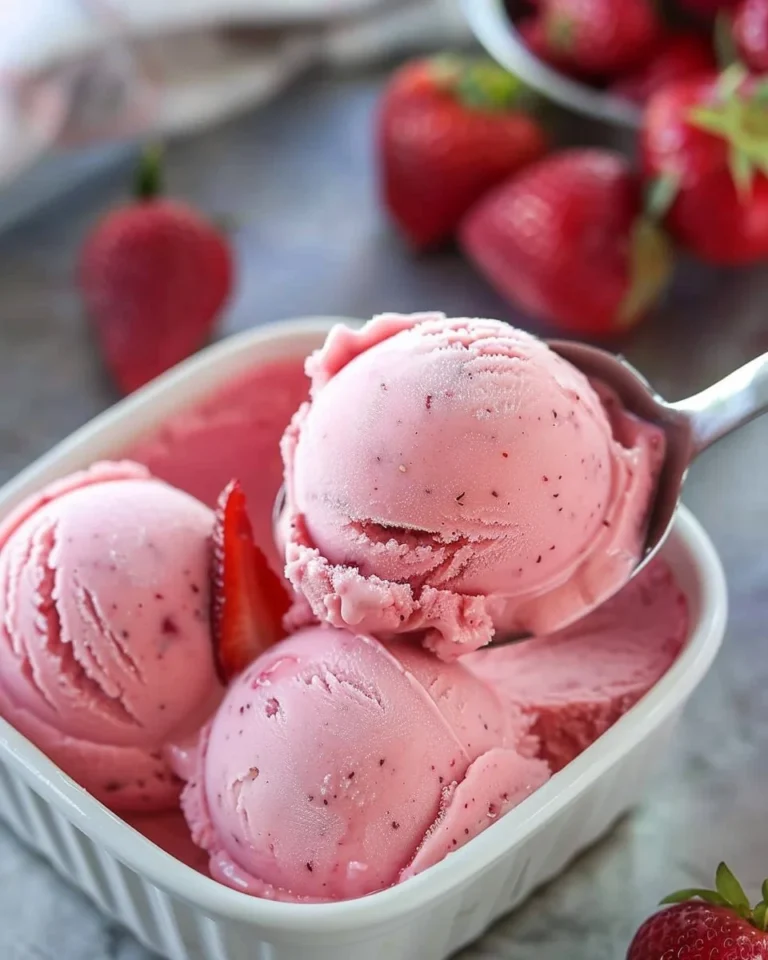 Delicious bowl of homemade strawberry frozen yogurt topped with fresh strawberries
