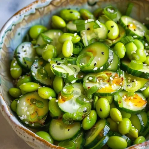Edamame and cucumber salad garnished with sesame seeds in a bowl